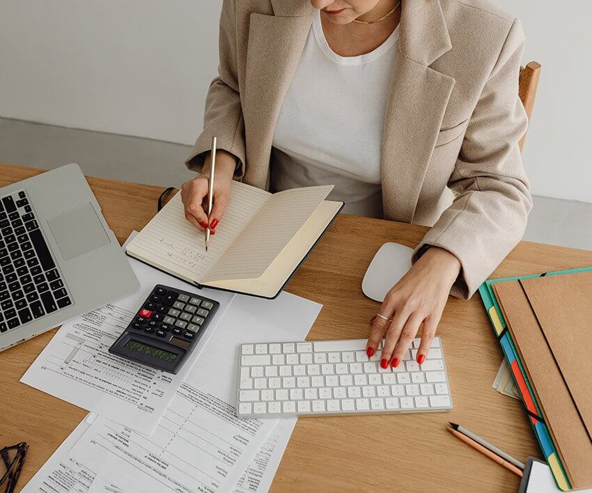 Image of female organizing business financial documents sitting at a desk.